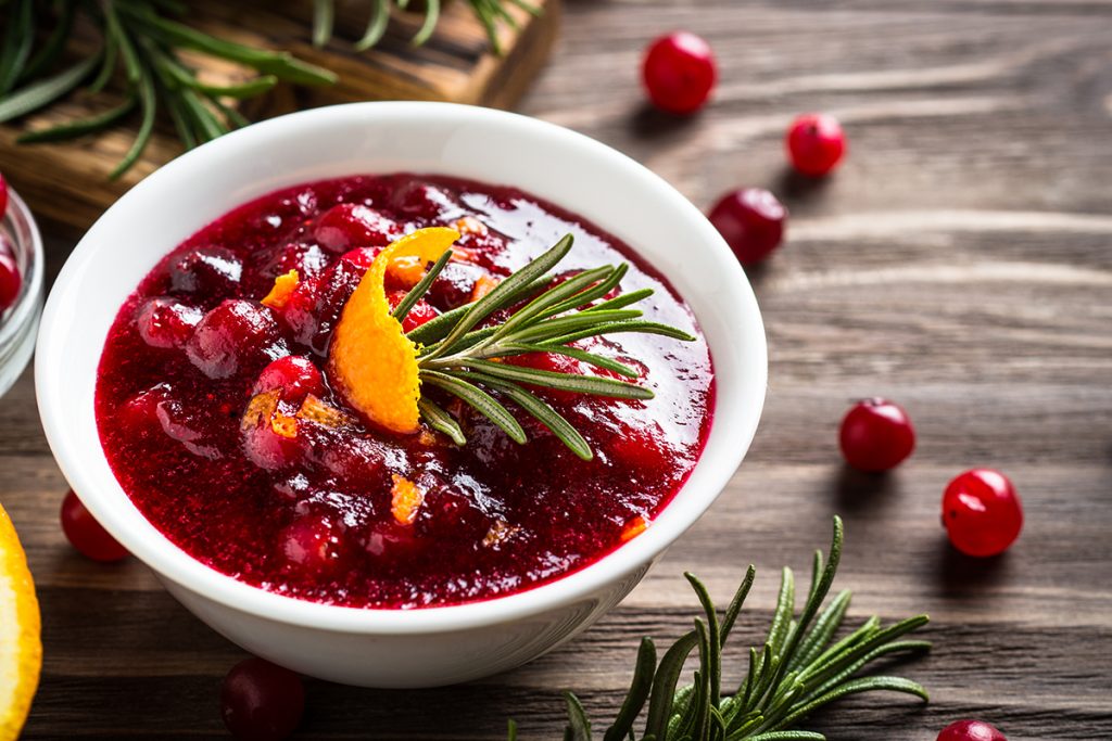 Cranberry sauce or cranberry jam with orange and rosemary. Close up.