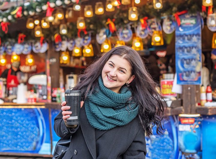 Happy woman buys gifts at festive Christmas market. Winter holiday and Christmas concept.